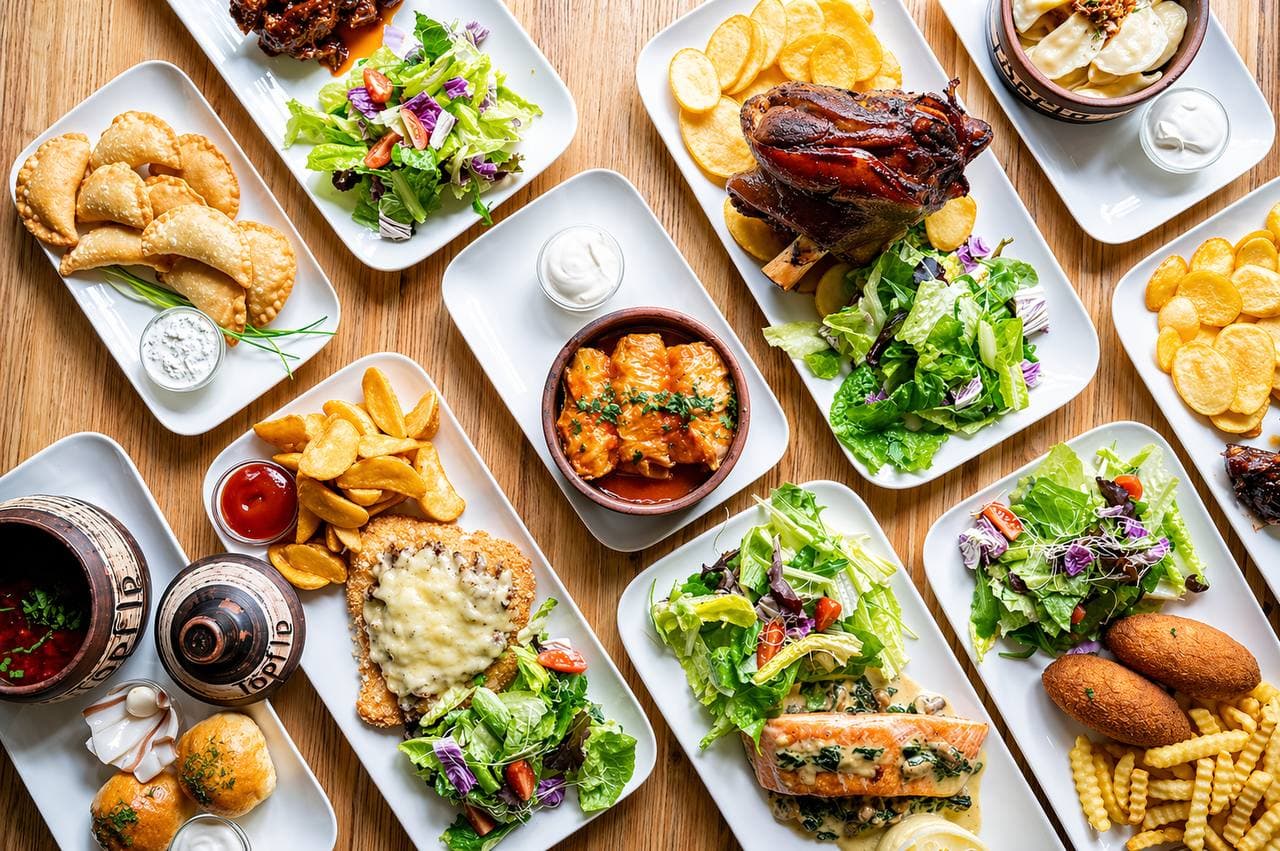 Auswahl ukrainischer Gerichte: Wareniki, Salate, Schweinshaxe, Kartoffeln und mehr