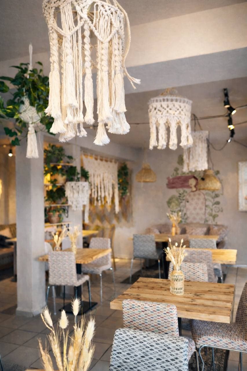 Innenraum mit Makramee-Lampen und Holztischen